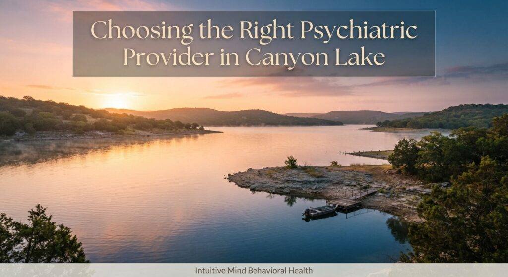 A serene, photorealistic landscape photograph capturing a panoramic view over Canyon Lake, Texas, during a warm, golden-hour sunrise. The tranquil water reflects the soft orange and pink light of the sky, with rolling hills and juniper trees in the distance. A small, rustic fishing dock and a single rowboat are moored in a quiet cove on the right. A large, semi-transparent overlay banner in the upper third contains the elegant, serif text: "Choosing the Right Psychiatric Provider in Canyon Lake". A subtle, understated footer bar at the bottom displays the text: "Intuitive Mind Behavioral Health". The overall mood is peaceful, reflective, and hopeful.