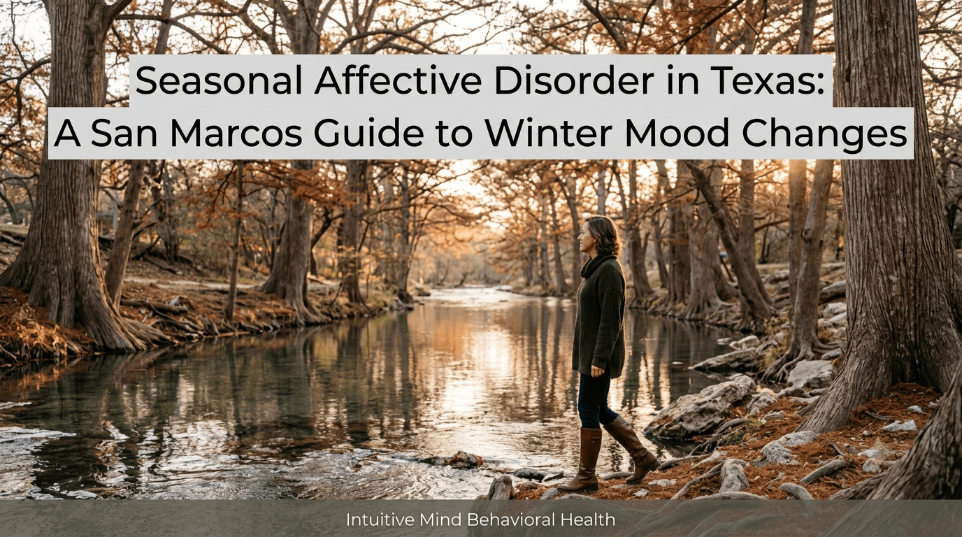 A photorealistic late afternoon scene along the calm, reflective San Marcos River lined with large, bare cypress trees and autumnal foliage. A woman wearing a green sweater and brown boots walks along the rocky riverbank under soft winter sunlight. A semi-transparent overlay at the top displays the title 'Seasonal Affective Disorder in Texas: A San Marcos Guide to Winter Mood Changes', with a subtle gray banner at the bottom reading 'Intuitive Mind Behavioral Health'.